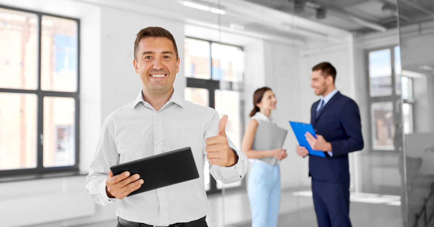 commercial real estate agent giving thumbs up in front of clients in a commercial building